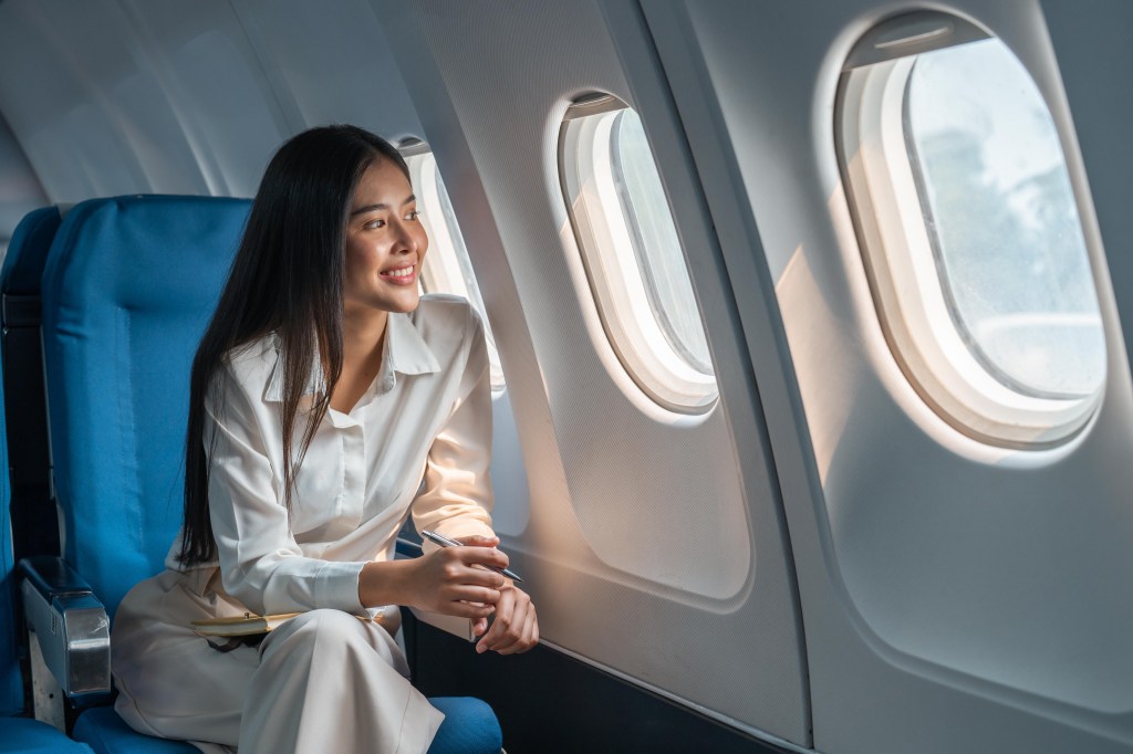 A female passenger in a window seat.