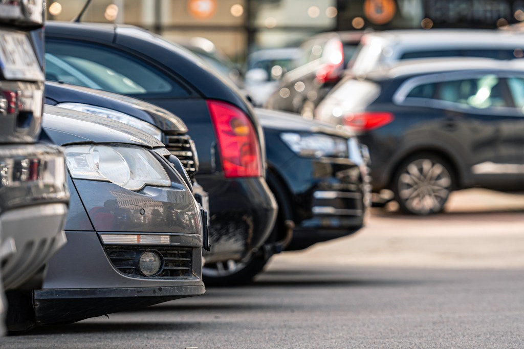 A close-up of a row of cars parked outside an office building