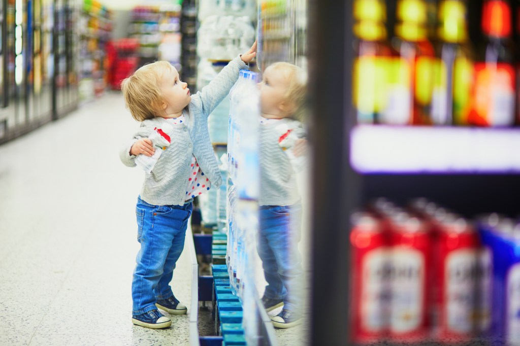 The toddler goes shopping in a large grocery or grocery store